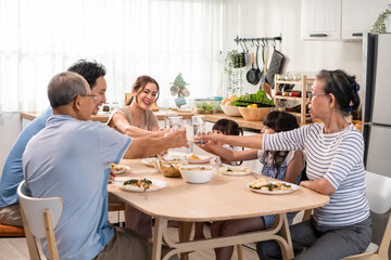 Asian big happy family have lunch on eating table together in house. 