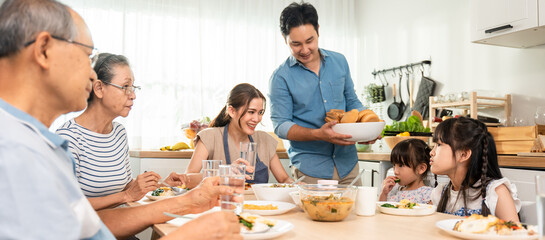 Asian big happy family have lunch on eating table together in house.