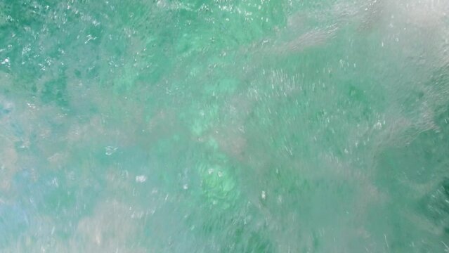 Slow motion shot of air bubbles coming out to the surface of a jacuzzi pool water