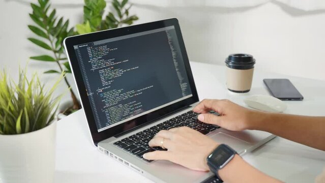Programmer woman writing program HTML code sitting at workplace in office, IT software developer hands typing data coding programming with laptop computer, IT start up concept, Web application design