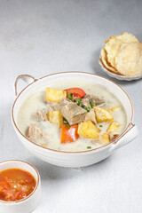 Soto Betawi. Traditional beef and offal soup from Betawi, Jakarta. The soup has been preplated in a bowl; ready to be served.