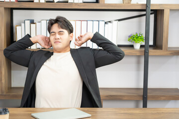 asian businessman wear formal suit sitting in office feeling bore and body pain by office syndrome