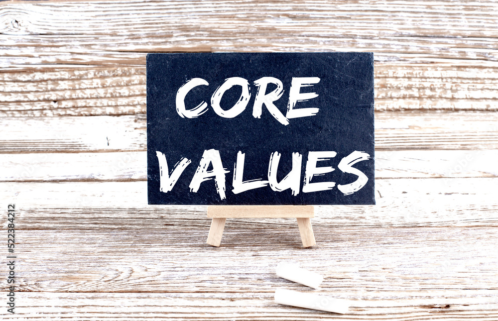 Poster core values text on the miniature chalkboard on wooden background
