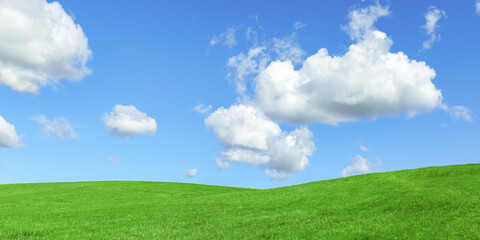 Green grass field and blue sky with clouds, aesthetic nature background, wide banner. Idyllic grassland, summer or spring landscape, green countryside fields, blue sky cloudy, bright colors nature