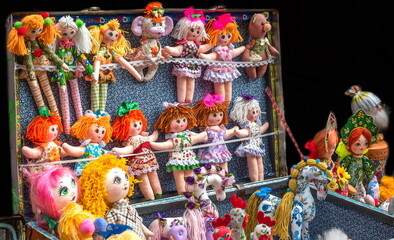 toy homemade rag dolls in a suitcase at the market
