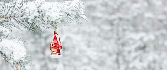 Background of winter Christmas holiday - toys on a branch of a Christmas tree and a blurred snowy...