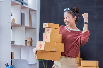 SME Online seller Young Asian woman freelance working on laptop tablet and box, checking online...
