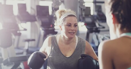 Boxer, athlete and fighter boxing, training and exercising in a gym, hitting a punching bag and working out for cardio and endurance. Chubby, plus size and overweight woman practicing for a fight - Powered by Adobe