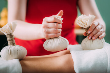 Kizhi massage or herbal bolus bags Ayurveda massage, hands of an Ayurveda Massage therapist...