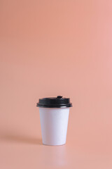 Coffee to go in a disposable paper cup on a white for mockup with copy space for text.