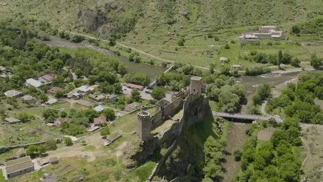 Khertvisi Fortress Overlooking Estuary Of Paravani And Mtkvari Rivers From The Rocky Mountain In Samtskhe-Javakheti Region, Georgia. Aerial Pullback Shot