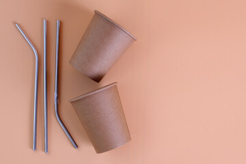 Disposable paper coffee cups and  stainless straw on pastel background. Environment and eco-friendly concept.