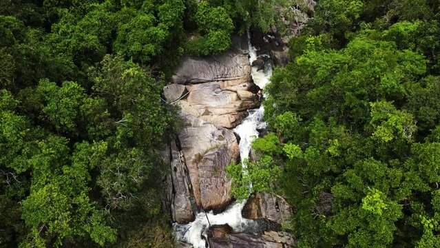 Drone shot of water flowing in the lush green environment of Than Sadet waterfall Koh Phangan, Thailand.