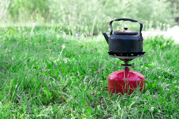 smoked kettle on a gas burner on the grass
