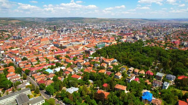 Aerial drone view of Cluj centre, Romania. Cityscape, roads with cars, old buildings, greenery