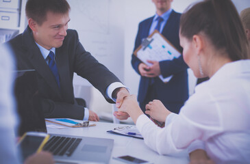 Business people shaking hands, finishing up a meeting, in office