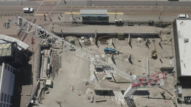 Drone Flying Over Luffing Jib Tower Crane In A Construction Site In Tacoma, Washington. aerial sideways top-down
