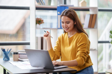 Beautiful Asian businesswoman is contemplating new ideas for her work with a bright and happy face.