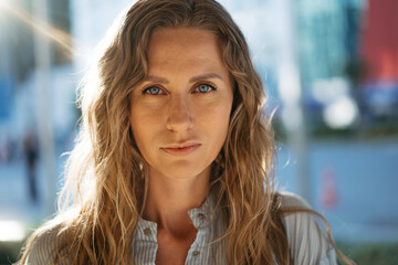 Portrait of a charming young woman posing for camera in the city