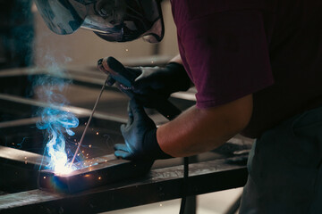 Industry worker welding iron pieces at work