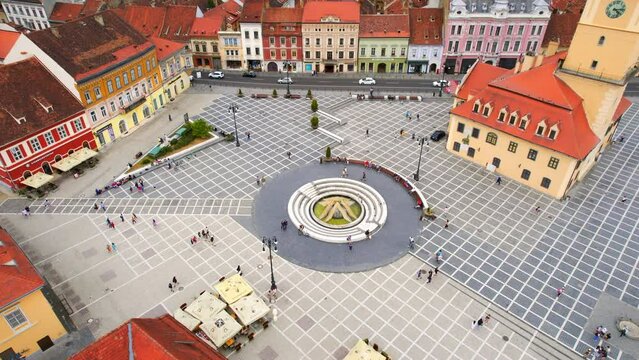 Aerial drone view of the main square in Brasov, Romania. Old city centre with museum of history, multiple buildings and people