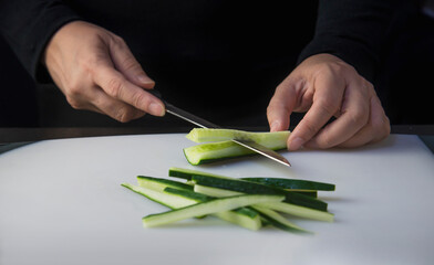chef is preparing fresh cucumber for making japan tradition cookery menu, japanese maki sushi roll serving in oriental restaurant, various different assorted luxury mixed healthy eating set concept