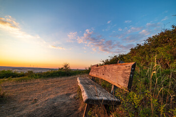 bench in the countryside with sunset and blue sky