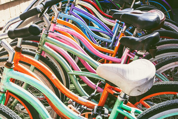 A view of several bicycles parked together in a lot.