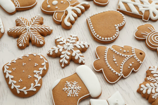 Different Christmas gingerbread cookies on white wooden table, closeup