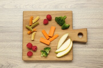 Board with different tasty finger foods for baby on wooden table, top view