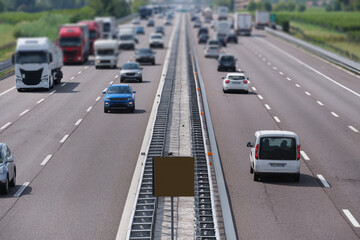 Car traffic in blur on european freeway aerial view. Italian motorways surrounded by vineyards.