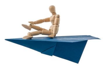 Wooden doll flying on a blue paper plane