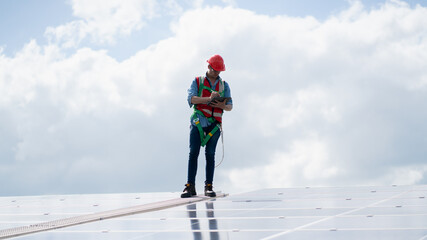 Fototapeta na wymiar Engineers, males inspecting solar panels on the roof, inspecting safety and cleaning services. Construction industry, construction personnel 