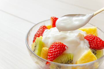 Eating yogurt. Yogurt and fruit in a glass bowl. Yogurt, fruit, vitamins, nutrients, breakfast,...