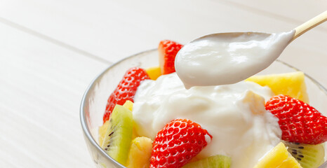 Eating yogurt. Yogurt and fruit in a glass bowl. Yogurt, fruit, vitamins, nutrients, breakfast, dessert, etc.　 ヨーグルトを食べる。ガラスの器に入ったヨーグルトとフルーツ。ヨーグルト、フルーツ、ビタミン、栄養素、朝食、デザートなど