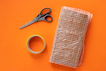 Cardboard box, bubble wrap and packaging tools. The concept of packaging parcels for an online store. View from above. 