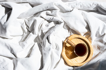 Cozy homely scene with coffee cup in bed. Morning concept.