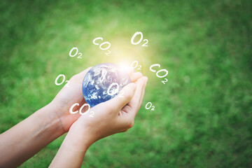 Hand holding earth with O2 and CO2 icon and nature background, Energy saving, Earth Day Concept.