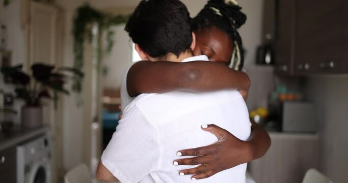 Affectionate lesbian couple kissing and embracing at home