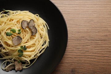 Tasty spaghetti with truffle on wooden table, top view. Space for text