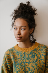 Black young woman wearing sweater posing and looking aside