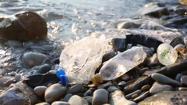 plastic pollution of Black sea. old crumpled bottle on coast. environmental protection