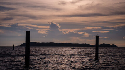 Fototapeta na wymiar Sunset scene with warning marking steel pole in the sea
