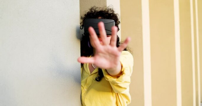 Woman using virtual reality simulator reaching out her hand