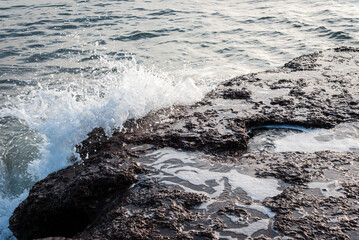 The waves breaking on a stony beach