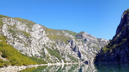 Albania, Lake Koman is a reservoir on the Drin River in northern Albania, surrounded by dense forested hills, vertical slopes, deep gorges and a narrow valley