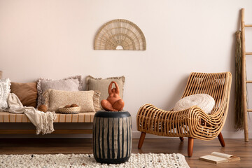 Sunny and bright space of living room with rattan armchair, chaise lounge, pillows, carpet,...