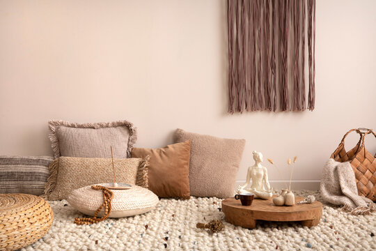 Boho And Cozy Interior Of Meditation Space With A Lot Of Pillows, Plaid, Hanging Macrame, Wooden Tray With Accessories, Decoration, Carpet And Personal Stuff. Warm And Minimalist Home Decor. Template.