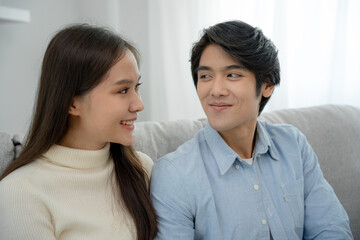 Asian couple smiling and happily looking into each other's eyes, cuddling, warm hugs, teenager's first love, married couple, warm family. Husband and wife are happy with new home.
