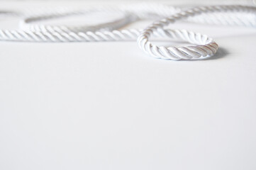 White rope cord silky silver textile tie curved lasso line background 